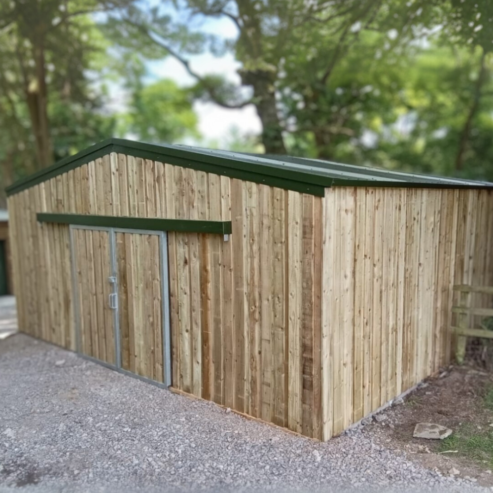 An image of a Kit Buildings UK steel-framed building - featuring sliding doors, posco green roof and castle boarding cladding