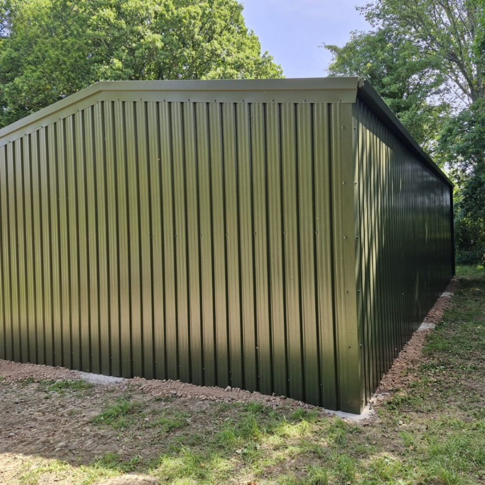Side view of an olive green open store - showing one of the closed ends and the back of the building