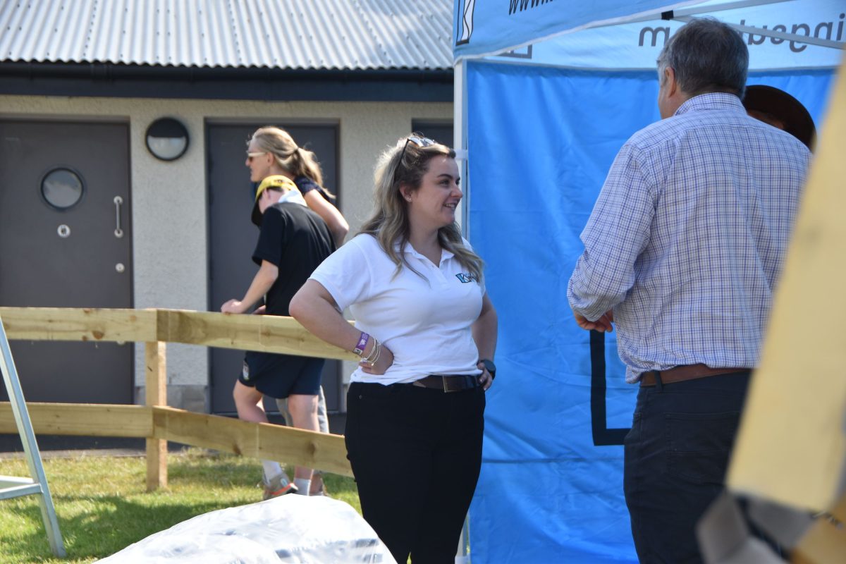 Amy standing outside of the tent chatting to a client