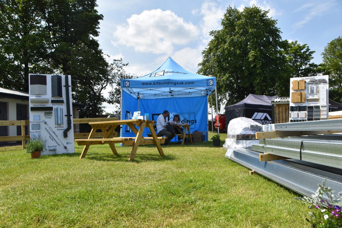 A long shot of Amy and a customer sitting under a blue Kit Buildings UK branded tent at the 2025 Royal Highland Show